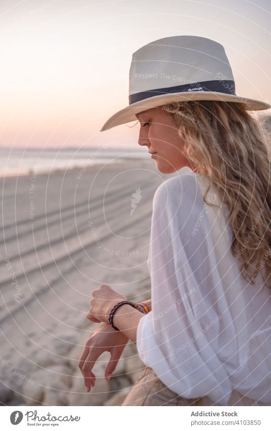Charming woman in hat leaning on fence and looking at sea Beach Girls Portraits Summer traveling seaside tourism charming vacation curly holiday freedom journey
