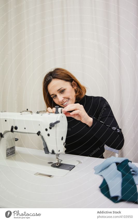 Seamstress using sewing machine in workshop seamstress woman fabric craft occupation material clothing female adult tailor part element detail professional