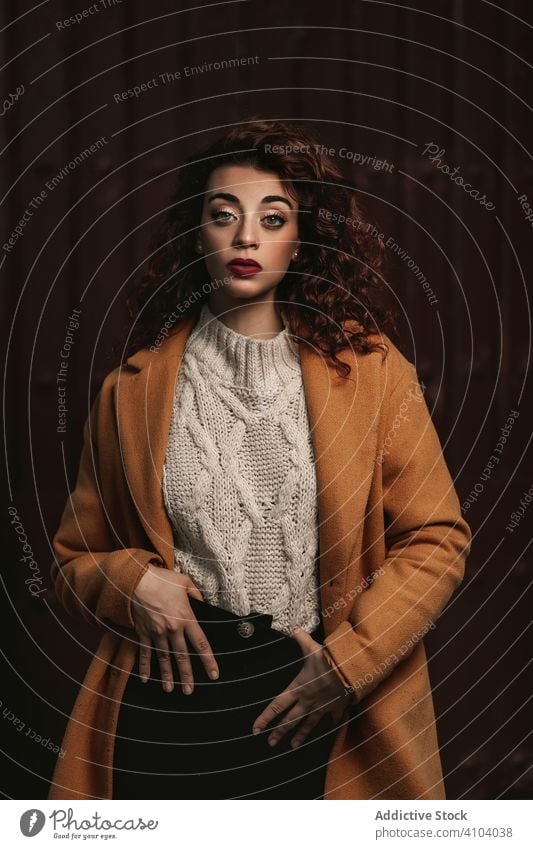 Curly haired woman with big grey eyes in casual brown haired strand portrait curly hair young face hand holding complexion appearance female model beautiful