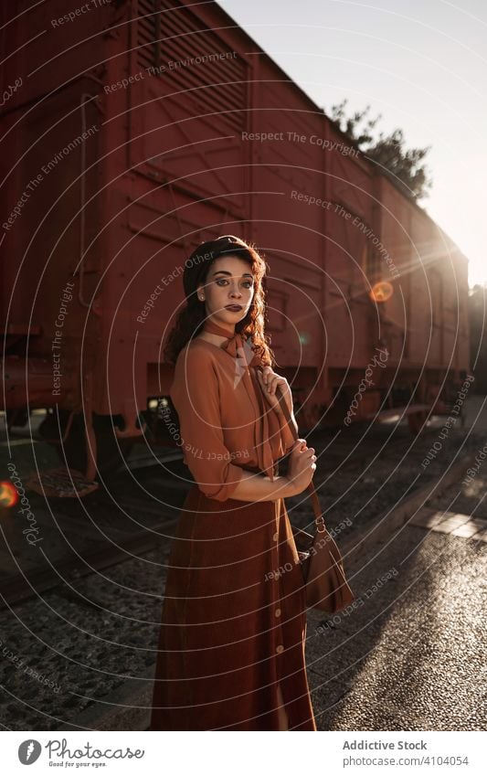 Female in vintage clothes standing on railway station and holding open book female terracotta train dreaming hand totally dark haired brunette retro rare