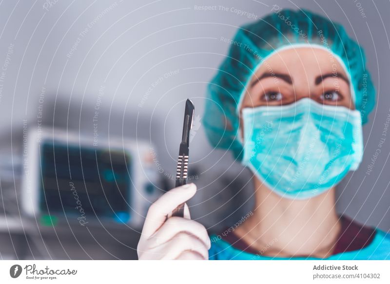 Female surgeon in operating theater hospital scalpel mask hat ready woman work doctor healthcare female sharp lancet sterile knife tool instrument job uniform