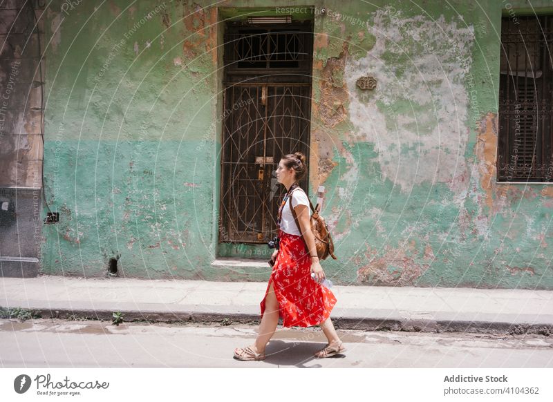 Young resting woman exploring city street during travel walking road route sidewalk building old ancient backpack tourism explore discovery female lady weekend