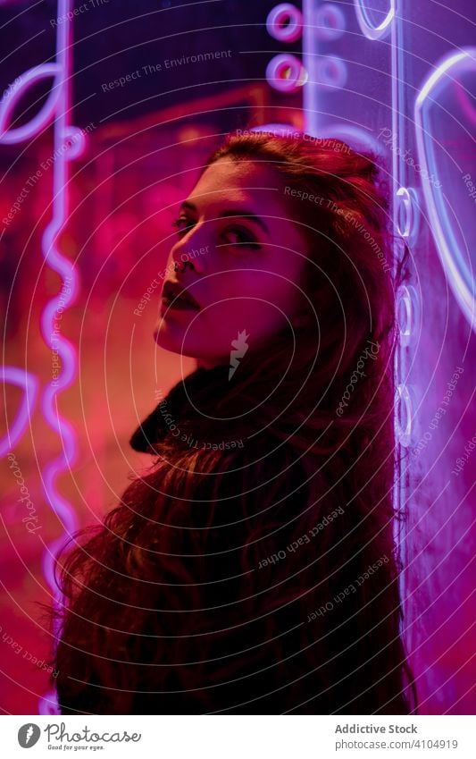 Female teenager in neon light hipster style sign female woman casual posture fashion cool design brunette culture millennial art city street extraordinary
