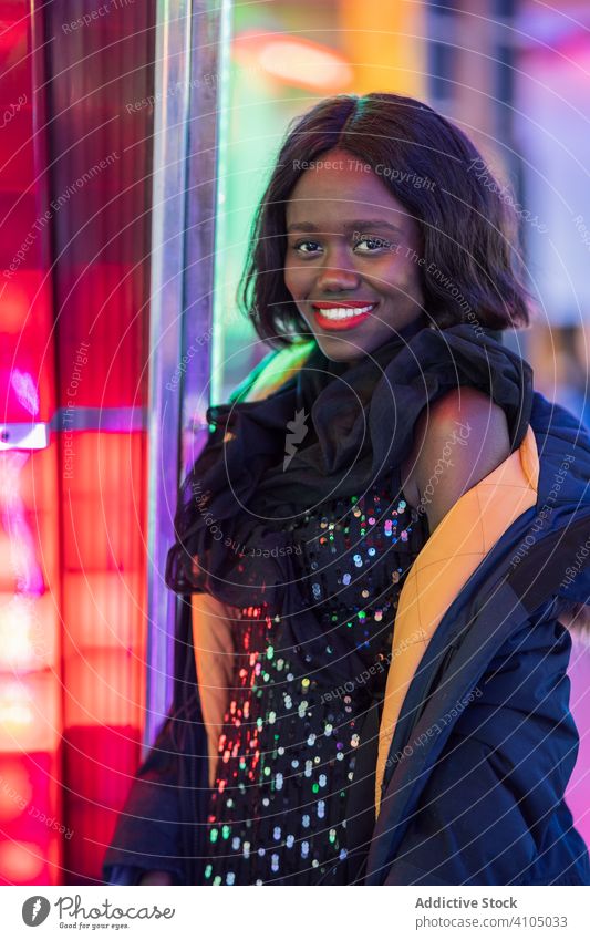 Cheerful black woman on funfair smile night arcade illumination weekend ethnic female amusement attraction colorful joy happy cheerful bright lady delighted