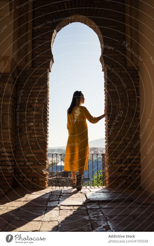 Female traveler in arch of old fortress woman building tourism shabby alcazaba malaga spain female trip journey visit destination architecture weathered brick