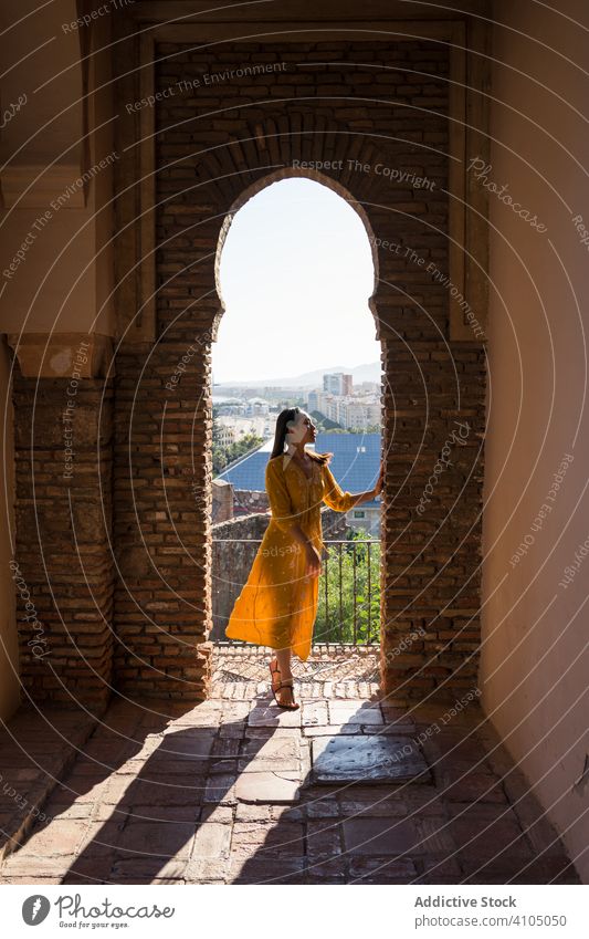 Female traveler in arch of old fortress woman building tourism shabby alcazaba malaga spain female trip journey visit destination architecture weathered brick