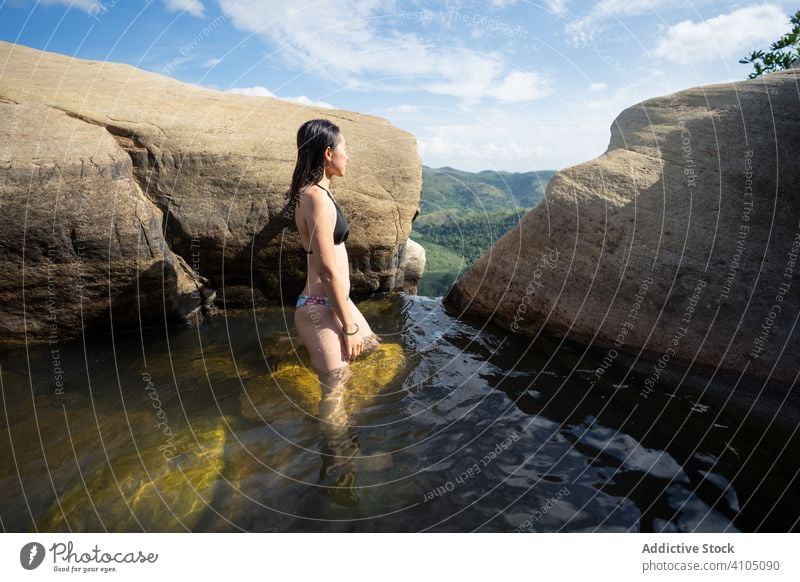 Inspired woman swimming in stony pool in mountain waterfall relaxation fun vacation holiday travel aqua recreation swimwear paradise rock nature landscape stone