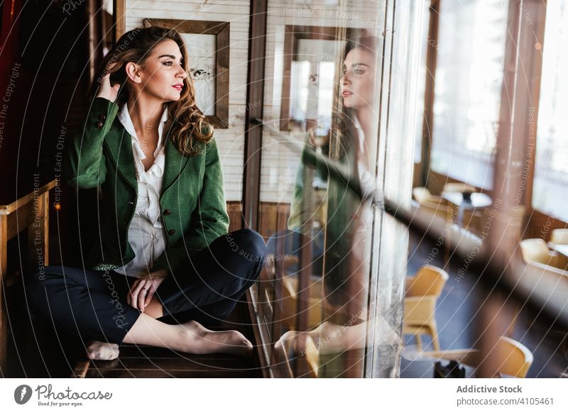 Thoughtful woman in stylish outfit in cafe fashionable trendy young casual lady female model wear clothes elegant charming accessories chic cafeteria lifestyle