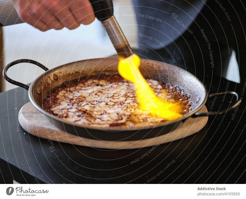 Process of cooking dish of haute cuisine in restaurant chef gas burner flame pan rice octopus platter plate carpaccio pepper aioli kitchen preparation