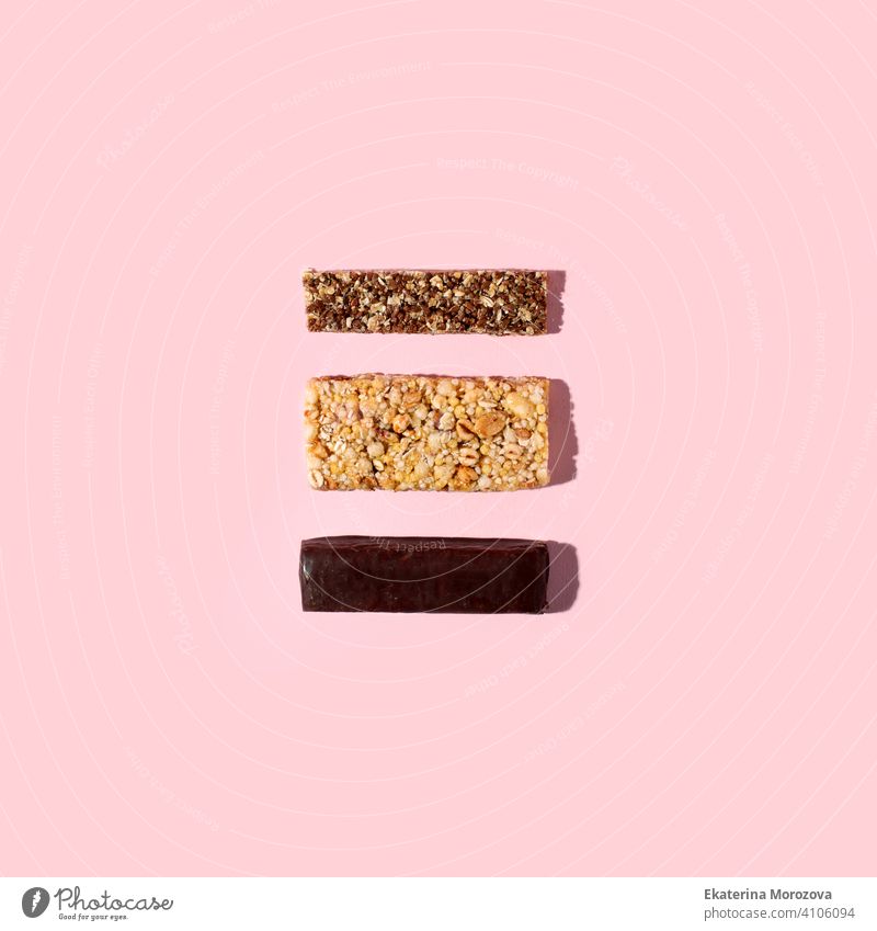 Top view of various healthy granola bars (muesli, chocoltae, protein, see, cereal bars). Set of energy, sport, breakfast and protein bars on pink background, minimal trendy flyer