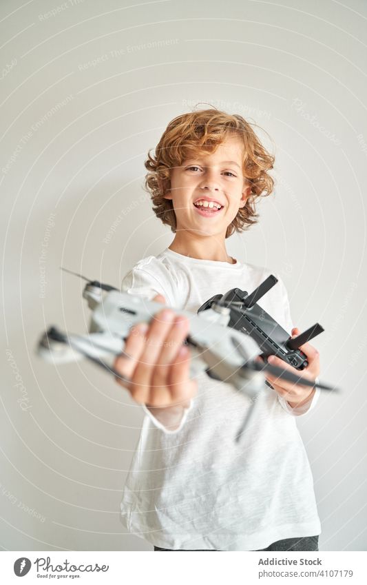 Child manipulating a drone and the remote control just given to him filming hobby robot motion aerial technology photography pilot discovery video sky operator
