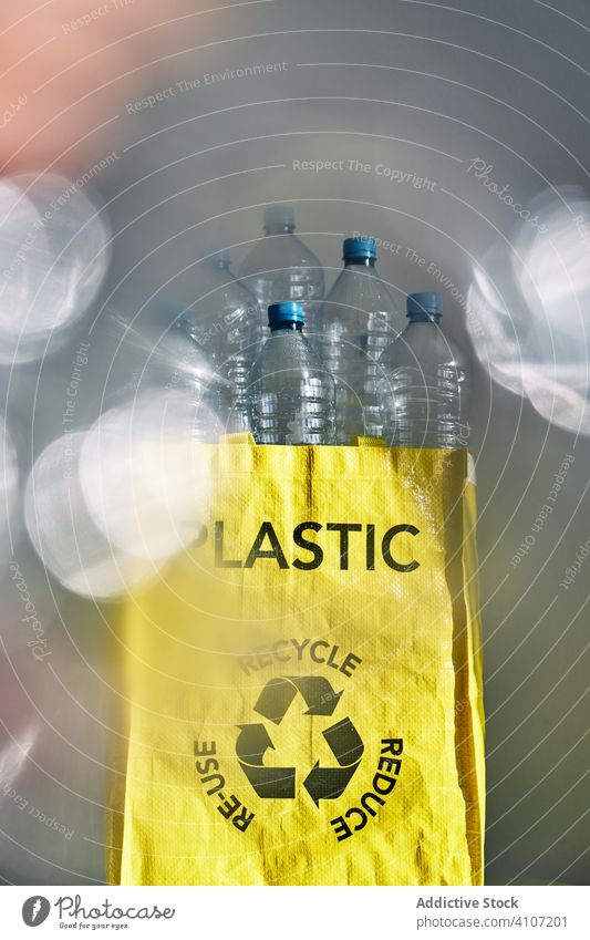 Plastic water bottles in yellow bag plastic heap pile recycle trash garbage environment waste problem rubbish ecology concept reuse clean pollution junk
