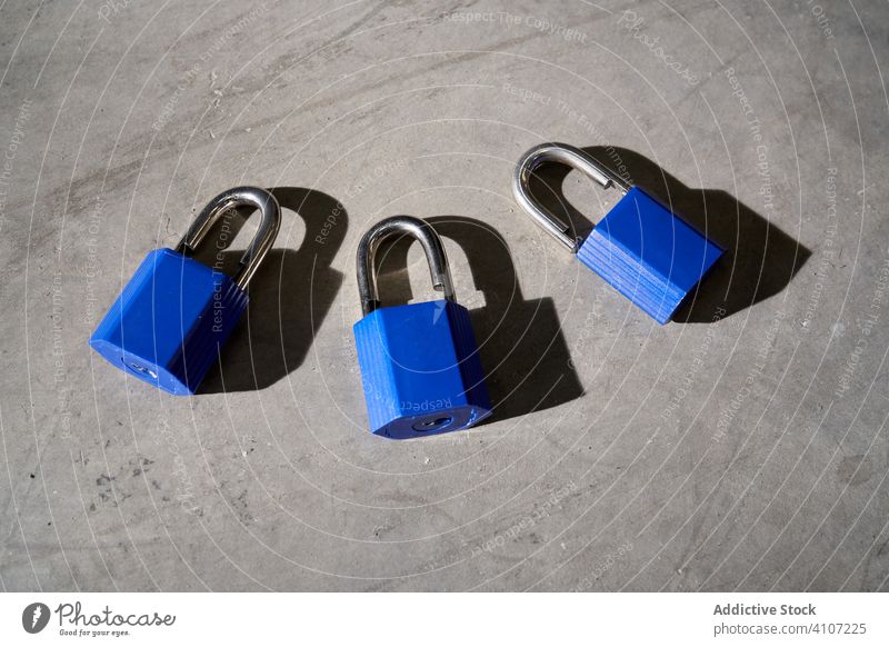 Padlocks on the concrete floor secure safety padlock security protection private safeguard metal object secured privacy access secret key protected steel blue