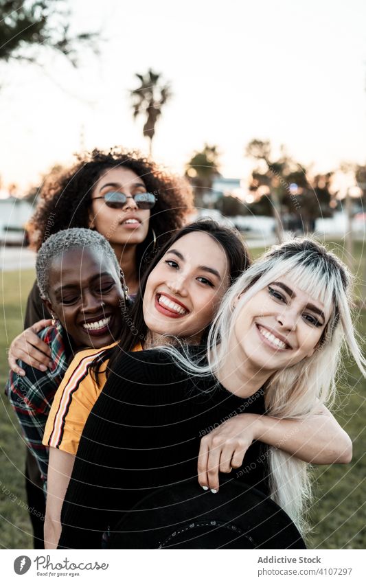 Multiethnic group of female hipsters cuddling with each one women young style smile hug portrait together friend diverse multiracial multiethnic hugging