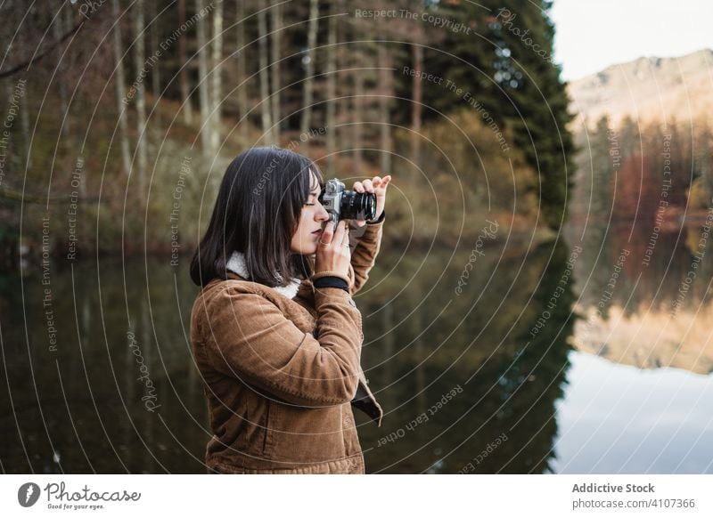Woman taking photo at lakeside woman forest photo camera landscape tranquil nature autumn scenic female young photographer artist water tree beauty beautiful