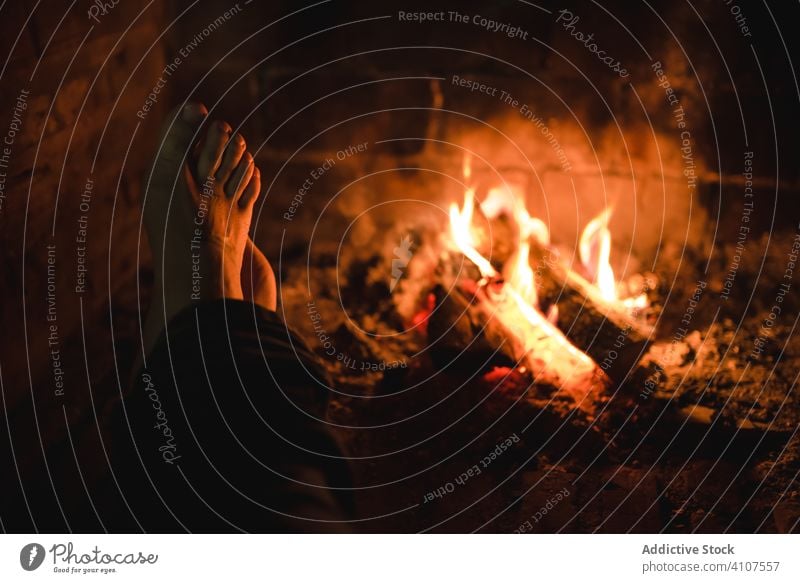 Silhouette of person warming feet near fireplace in dark house silhouette cozy weekend rural living bonfire cuddle home comfort wood night heat barefoot