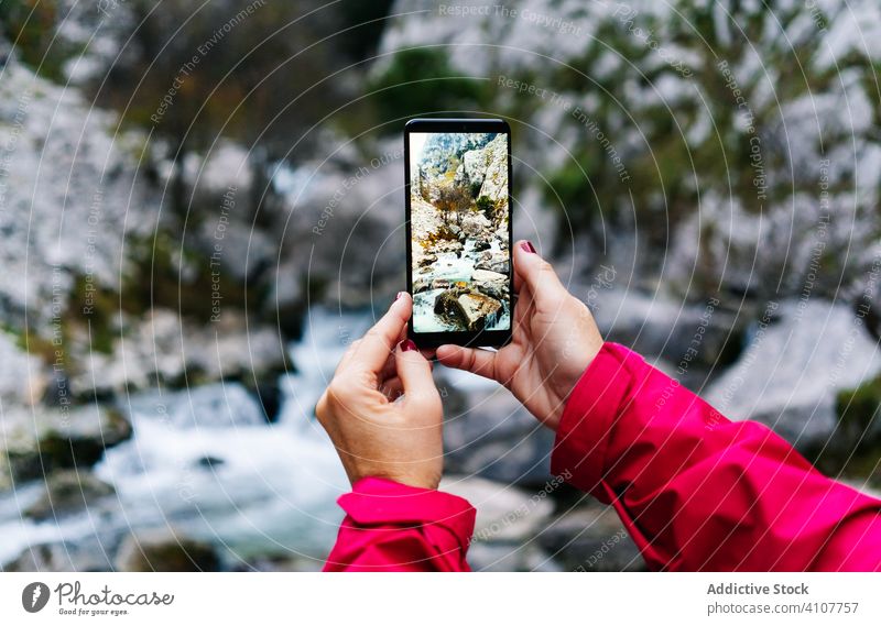 Anonymous person taking photo of mountain landscape on smartphone screen using gadget device camera picture display photographer capture image digital tourist