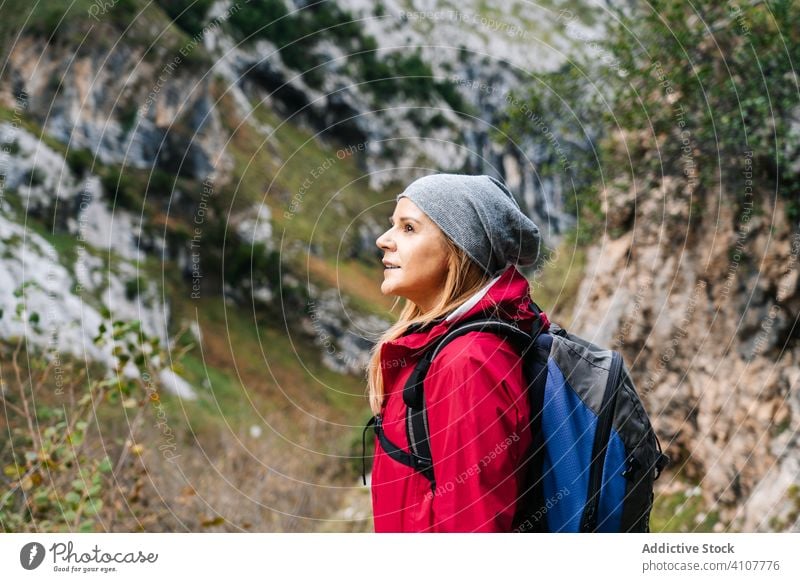 Tourist with backpack standing among high rocks woman tourist peak female mountain hill travel nature trekking landscape sky tourism adventure dangerous extreme