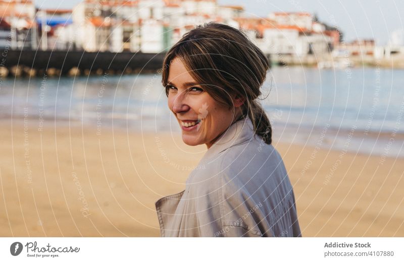 Cheerful adult woman laughing standing on waterfront in daytime shore cheerful pier fun relax happy overjoyed street female spain casual positive urban excited