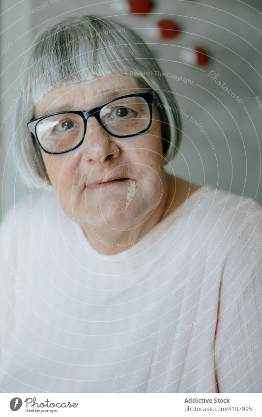 Old woman looking at camera old elderly senior home female pensioner serious natural blouse contemporary communication white mature aged grandma gray hair