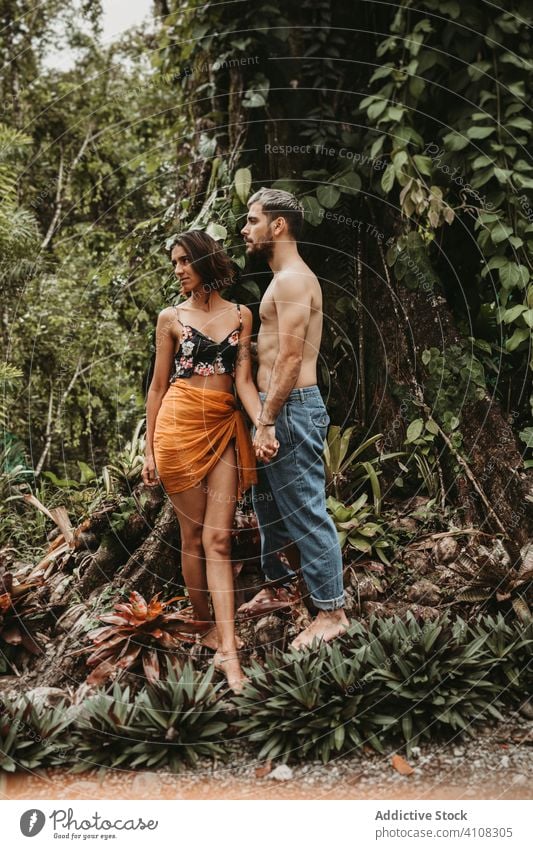 Happy couple on vacation in rainforest tropical sensual exotic together female jungle holding hands nature plant green lifestyle peaceful serene barefoot