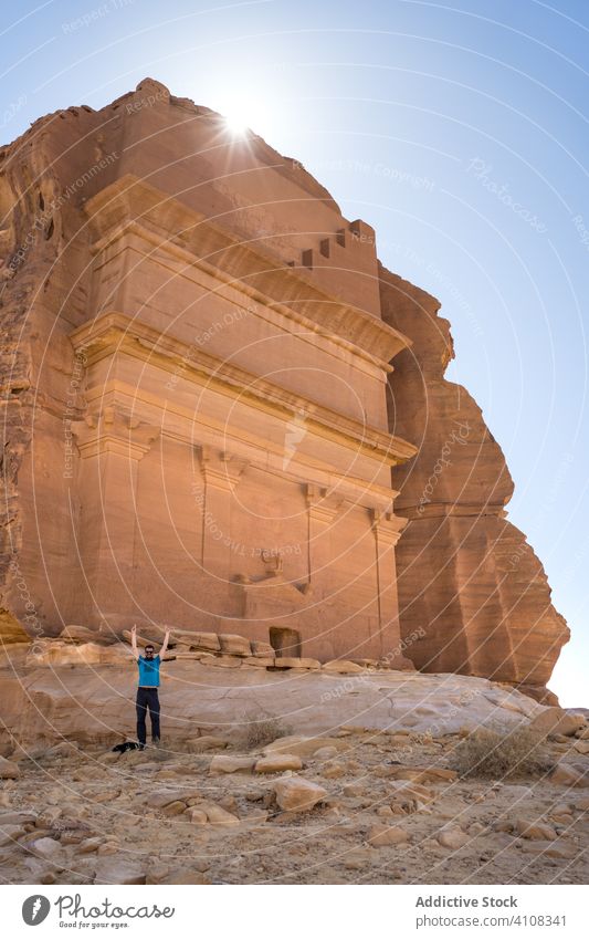 Male tourist enjoying sightseeing in desert man tomb carved cliff traveler freedom male vacation tourism culture grave religion architecture old location
