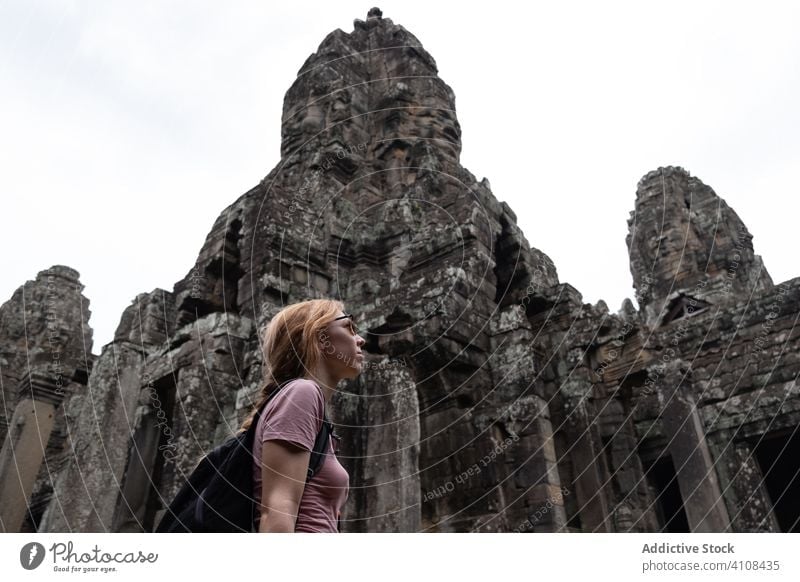 Tourist enjoying sightseeing tourist vacation woman ancient hindu temple traveler female watch religious tourism asia cambodia angkor wat architecture building