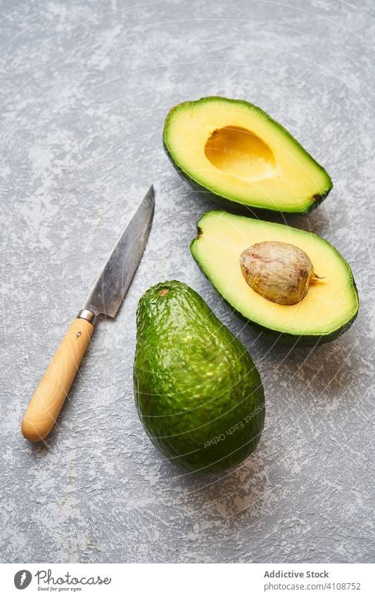 Cut avocado on grey texture background cut fresh raw green tropical healthy fruit slice food diet natural vegetarian ingredient vegetable nutrition ripe seed