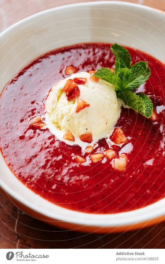 Haute cuisine dessert of ice cream and sweet sauce strawberry syrup restaurant mint delicious food tasty fresh red bowl dish gourmet portion plate organic