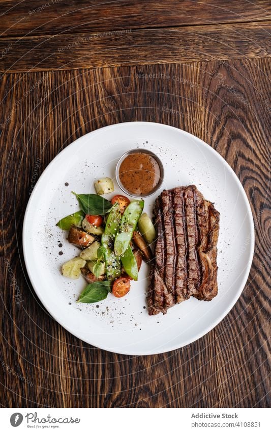 Delightful grilled beef steak with vegetables on plate basil bbq serve sauce food meat dish meal tasty delicious cuisine gourmet dinner fresh lunch cooked