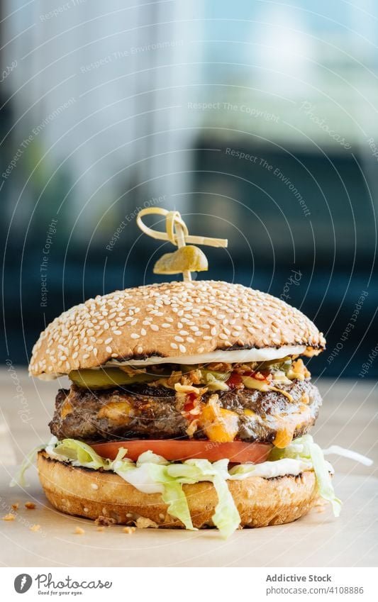 Tasty hamburger on plate in restaurant junk food snack fast food meal tasty lunch patty cutlet lettuce tomato cheese cucumber bun sesame calorie portion dish