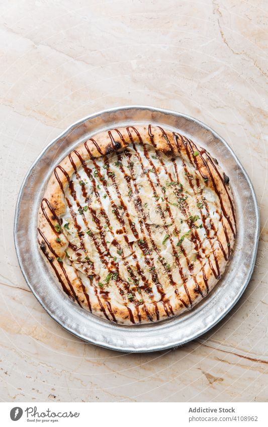 Round pizza with bananas and chocolate sauce on metal tray dessert sweet nut crushed mint topping sugar pie confectionery gourmet delicious cuisine crunch