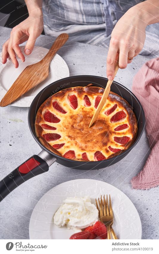 Unrecognizable lady slicing pie with knife baked dessert cutting cook woman serving decorating strawberry sour cream female chef homemade household pan dish