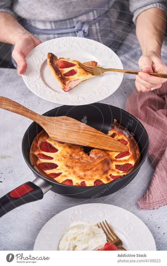 Unrecognizable lady slicing pie with fork baked dessert cutting cook woman serving decorating strawberry sour cream female chef homemade household pan dish bowl