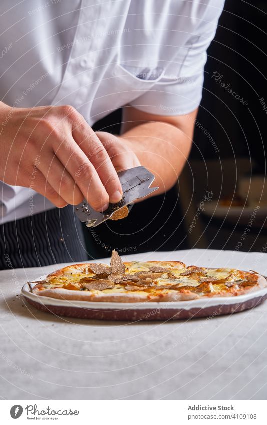 Crop chef slicing truffle on pizza slice restaurant cook table cuisine man dinner fine food luxury dish meal expensive gourmet plate lunch excellent shaver tool