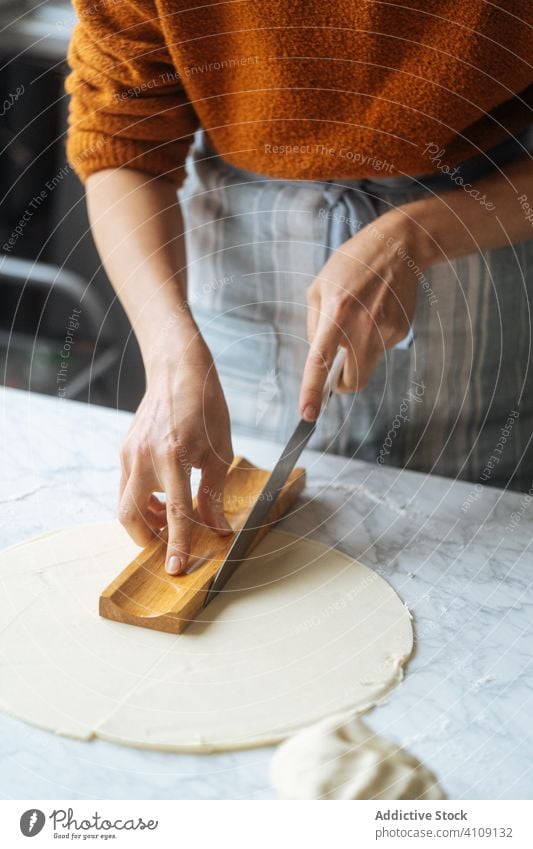 Cook cutting dough with knife in shape on table preparation cook bakery kitchen homemade culinary making apron recipe food prepare raw knead cuisine traditional