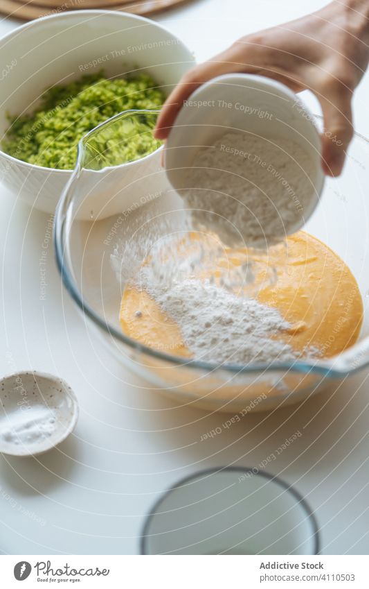 Person pouring flour into bowl with vegetable mixture cook cooking kitchen food cuisine ingredient chef preparation recipe healthy jug bakery culinary organic