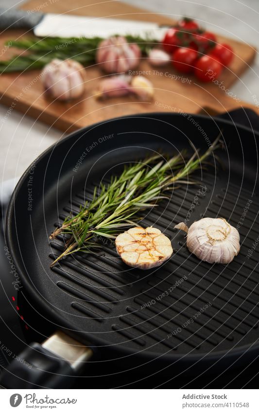 Grill pan with rosemary and garlic in kitchen grill seasoning herb cooking food aromatic frying meal flavour ingredient product cuisine roast cut sprig recipe