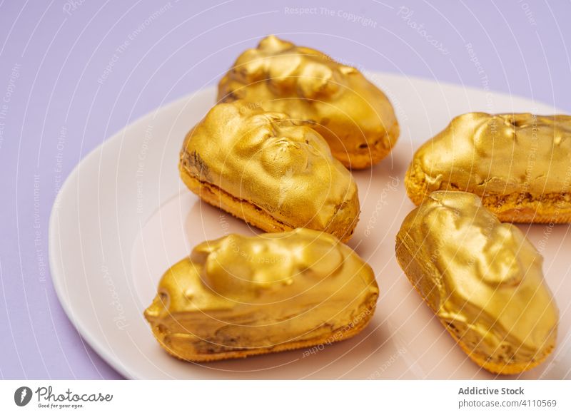 Tasty eclairs with golden icing dessert plate sweet food pastry tasty cuisine dish delicious yummy scrumptious sugar calorie portion baked gourmet prepared