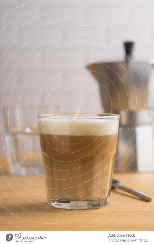Fresh coffee with milk in glass froth beverage drink caffeine latte cappuccino cup foam brown breakfast wooden hot brew service table fresh morning tasty