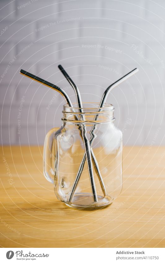 Metal straws in glass jar on table metal several eco friendly reject steel shiny empty jug wooden reusable stainless tubule sustainable silver equipment