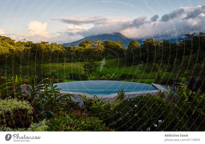 Swimming pool in tropical valley near mountain resort water green evening nature costa rica cloudy sky peak landscape scenic picturesque tourism idyllic
