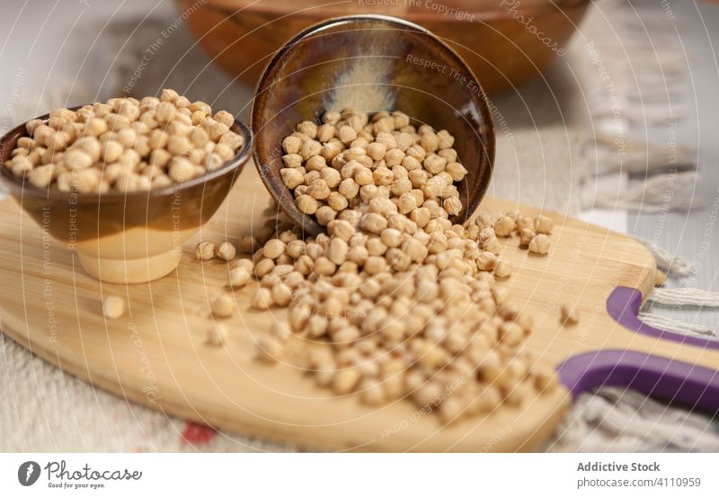 Bowls with raw chickpea on cutting board bowl kitchen table food ingredient healthy organic nutrition natural fresh seed diet kitchenware utensil spill heap