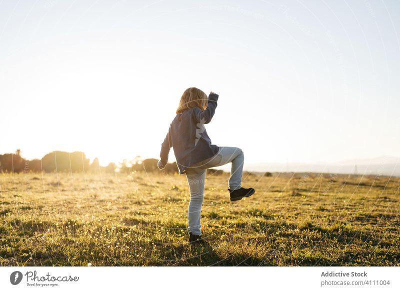 Little girl having fun in field kid happy nature child enjoy play dance sunset meadow countryside freedom grass summer carefree female sky childhood adventure
