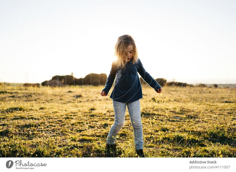 Little girl having fun in field kid happy nature child enjoy play dance sunset evening meadow countryside freedom grass summer carefree female sky childhood