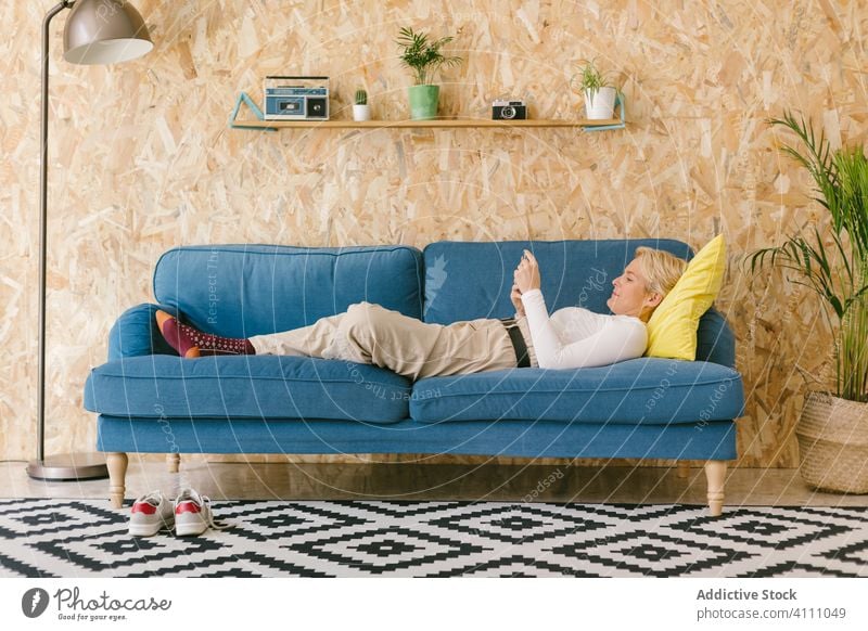 Woman resting on couch during workday businesswoman break smartphone using relax lying design office comfort sofa leisure manager entrepreneur professional