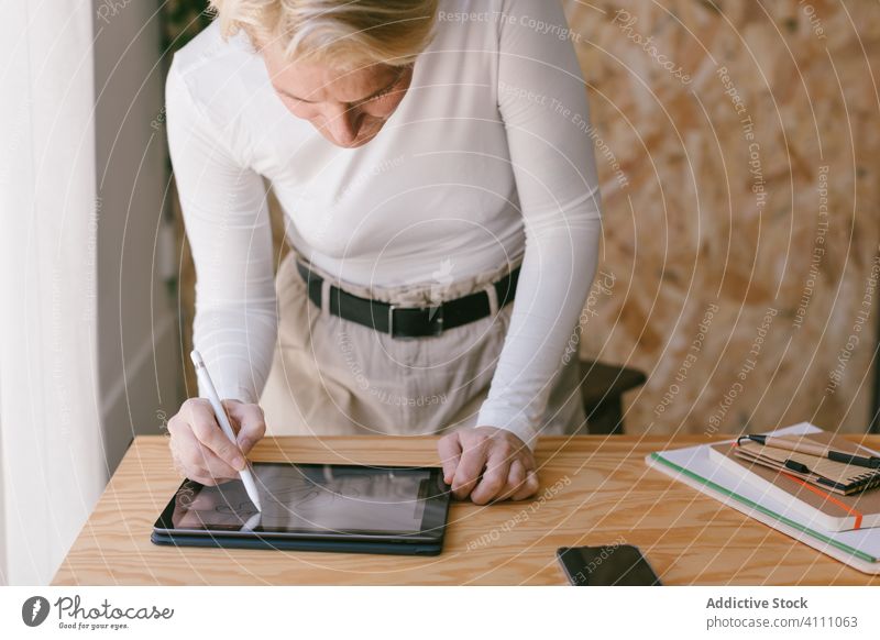Focused woman using tablet with stylus working in office businesswoman desk designer workplace creative occupation draw contemporary employee concentrate
