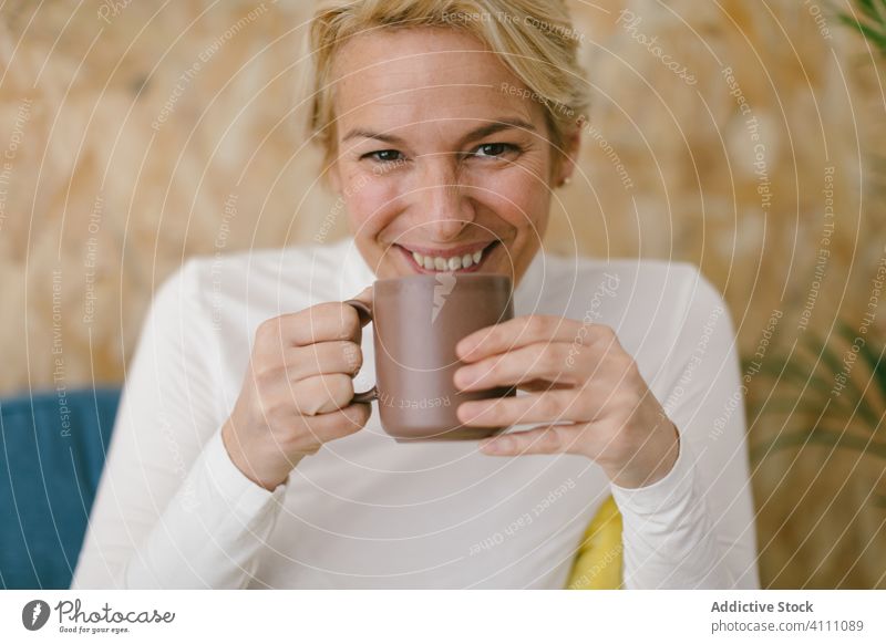 Relaxing woman with coffee cup on couch rest business office mug chill beverage drink leisure modern casual smile adult interior tea sofa relax happy content