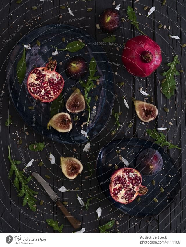 Figs and pomegranates with herbs fruit plate fresh table knife fig arugula organic ripe food sweet tasty delicious vegetarian vegan vitamin snack natural diet
