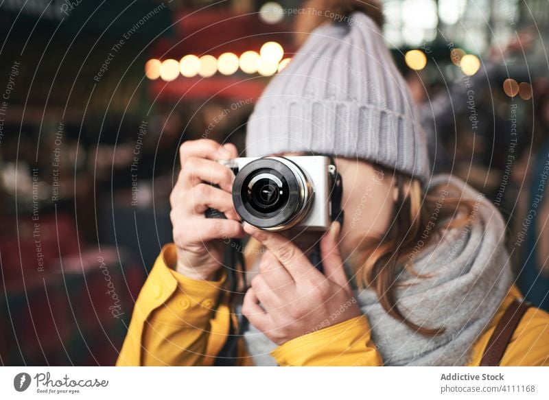 Woman taking photo with camera in city woman photography travel winter evening take photo street casual female tourism warm clothes hobby vacation shoot device